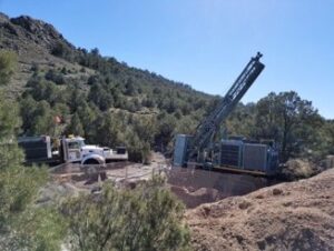 A surface diamond drill rig on a hillside drill pad.