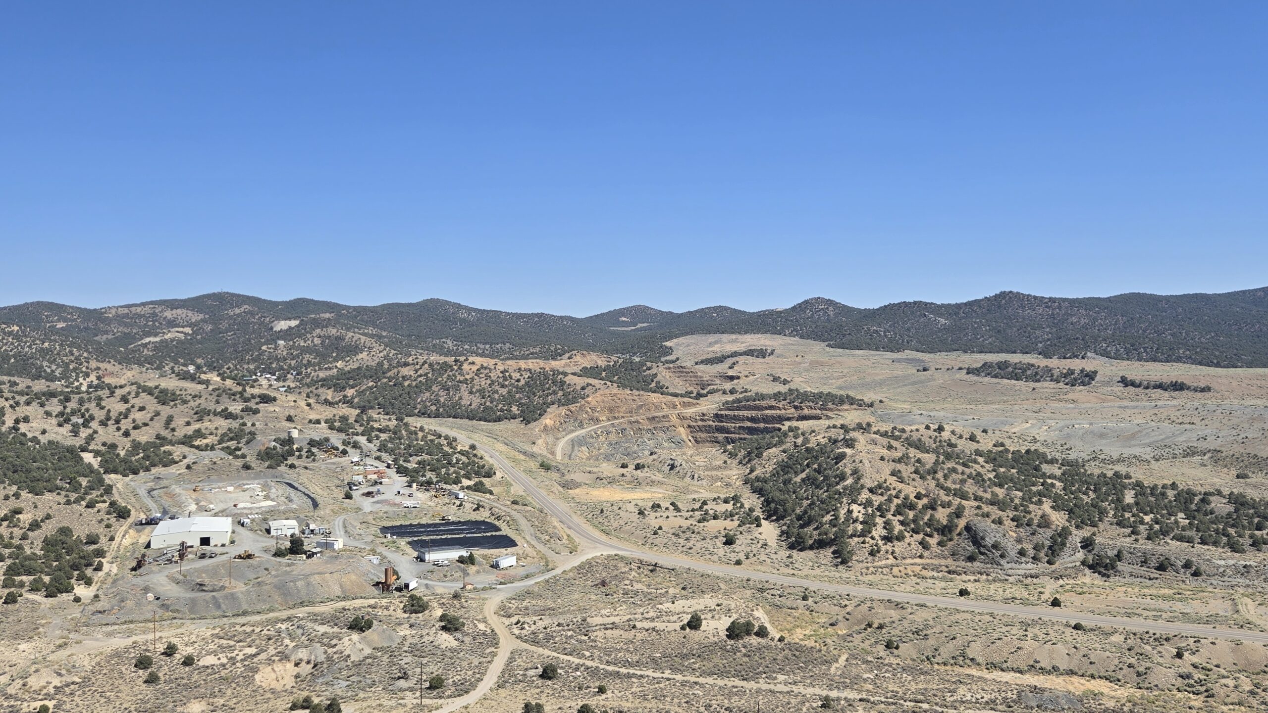 Mine facilities, access roads and a terraced open pit in the Manhattan District